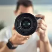 Man takes photo of himself in the mirror with a mirrorless camera. Self-portrait.