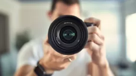 Man takes photo of himself in the mirror with a mirrorless camera. Self-portrait.